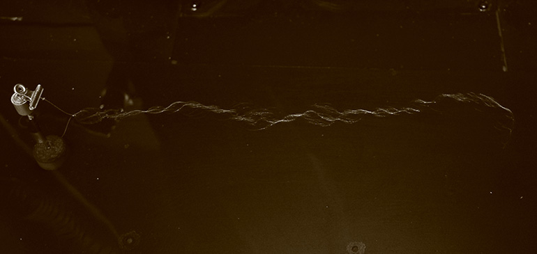 社内の試験設備を用いて糸を交絡させている様子の写真